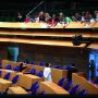 Schoolklas op bezoek in de Tweede Kamer praat met Kamerleden tijdens een schorsing. 